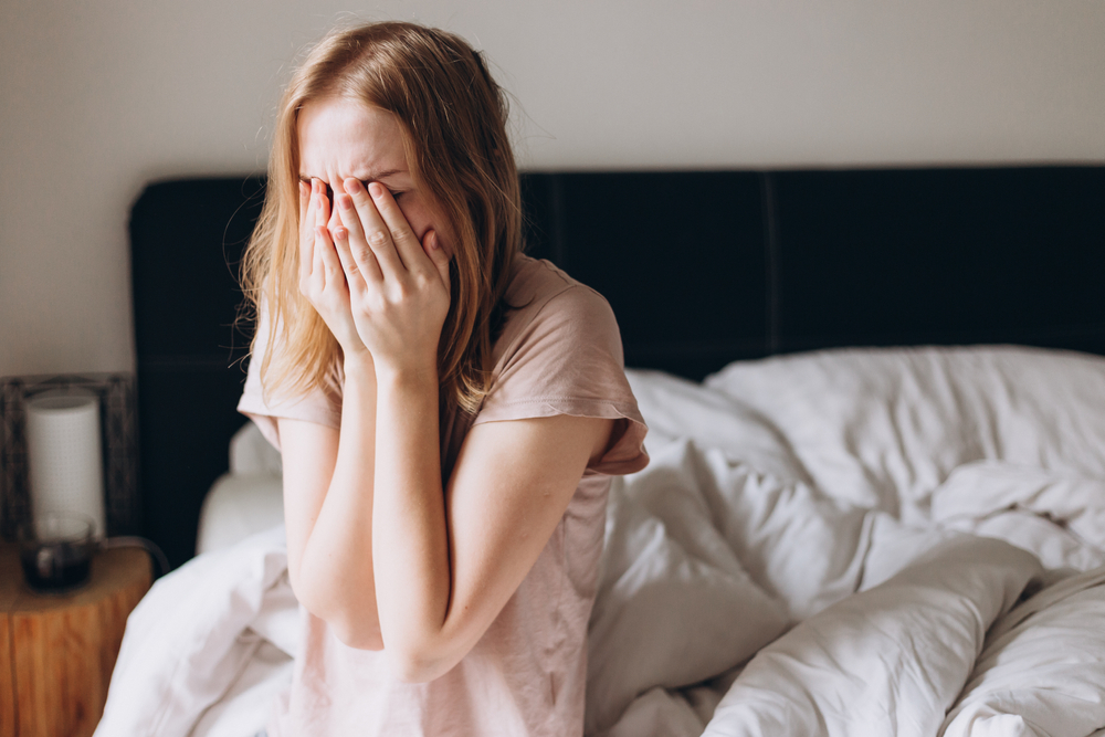 Woman crying lonely in bedroom
